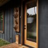 Front door with Resource Furniture Piano multi-purpose rack, KOHLER Triton faucet used as a footwash, August Doorbell Cam Pro, Rich Brilliant Willing Crisp (copper) lighting, ipe deck, Reed Wilson Design welcome matt and cedar window trim.